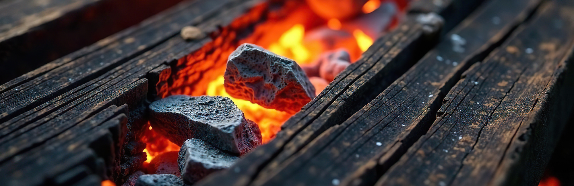 Close-up of glowing charcoal briquettes in a fire pit